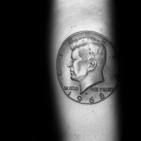 Realistic tattoo of a 1968 Kennedy half-dollar coin, featuring intricate shading and fine details for a three-dimensional effect.