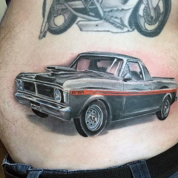 Realistic Ford GT351 pickup truck tattoo on the abdomen, featuring bold shading, fine details, and a classic muscle truck design with red stripes.