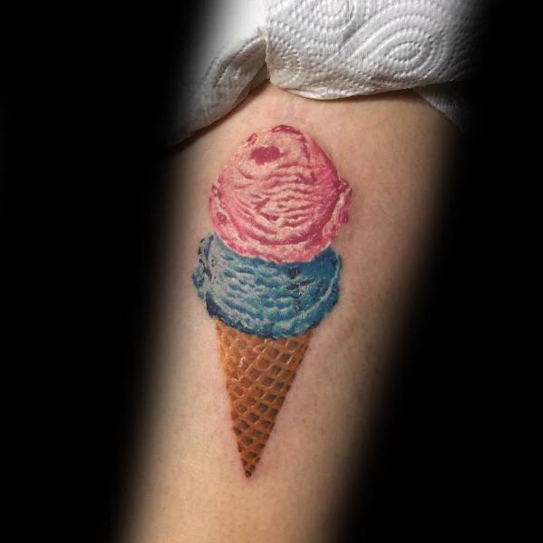 Realistic tattoo of a double-scoop ice cream cone with pink and blue swirled scoops, detailed textures, and shading for a lifelike effect.