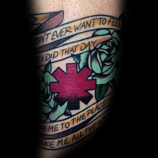 Tattoo featuring the Red Hot Chili Peppers logo surrounded by green roses and bannered lyrics from *Under the Bridge*, creating a bold and nostalgic design.