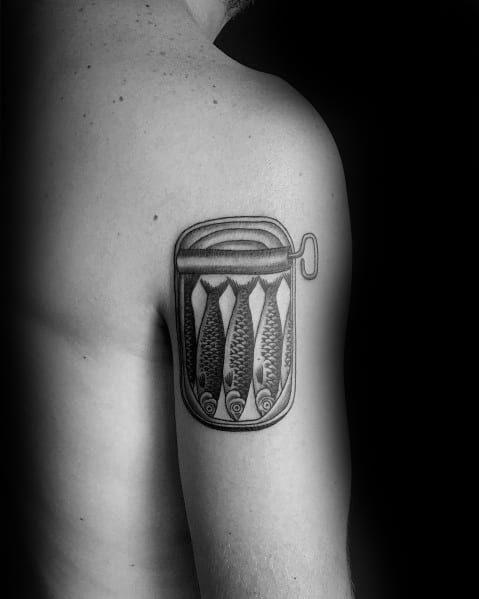 Black and grey sardine can tattoo on a man's upper arm, featuring fine line details and shading for a unique and artistic design.