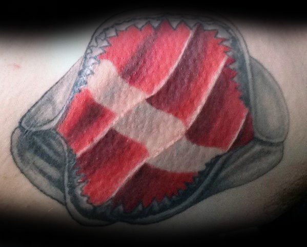 Tattoo of a dive flag appearing through torn skin with jagged edges, symbolizing a deep passion for scuba diving and an unbreakable connection to the ocean.