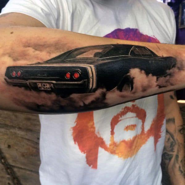 Realistic Dodge Charger tattoo on forearm, featuring a smoky burnout effect and detailed shading for a bold muscle car design.