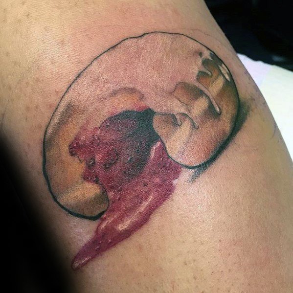 Tattoo of a bitten jelly-filled donut with realistic dripping filling and soft shading for a dramatic, mouthwatering effect.