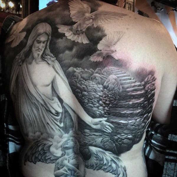Detailed black and white back tattoo depicting a landscape with doves and religious figures