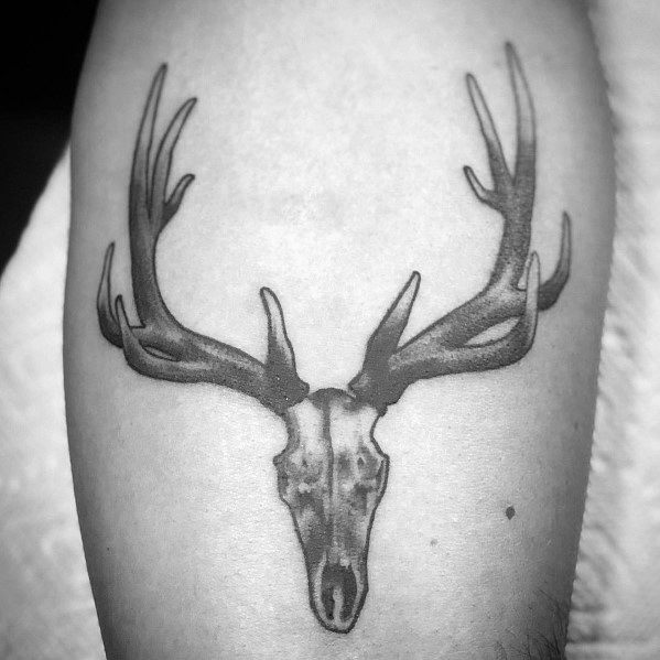 Black and grey elk skull tattoo on the forearm, featuring bold antlers and fine shading for a rugged and minimalist design.