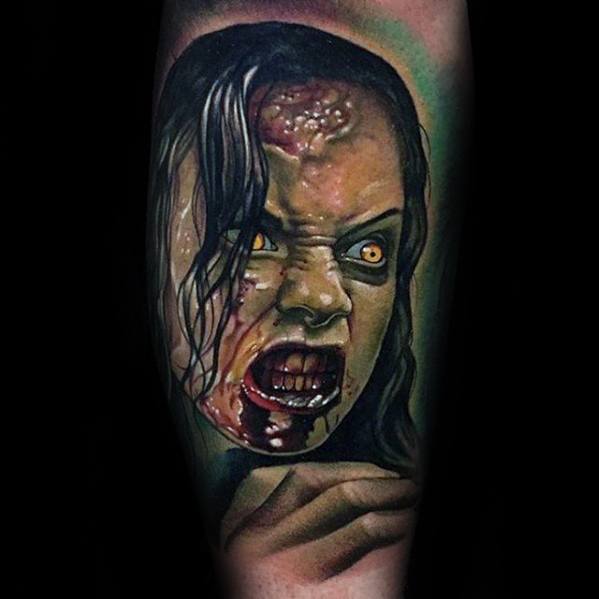 Terrifying Evil Dead tattoo of a possessed woman with glowing yellow eyes, bloodied mouth, and intense expression in vivid color realism.