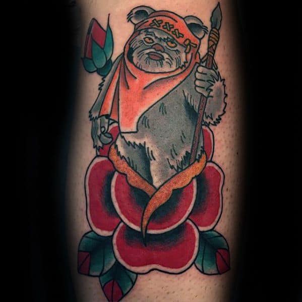 Neo-traditional Ewok tattoo holding a spear, standing on a bold red flower with teal leaves and wearing an orange hood with stitched detail.