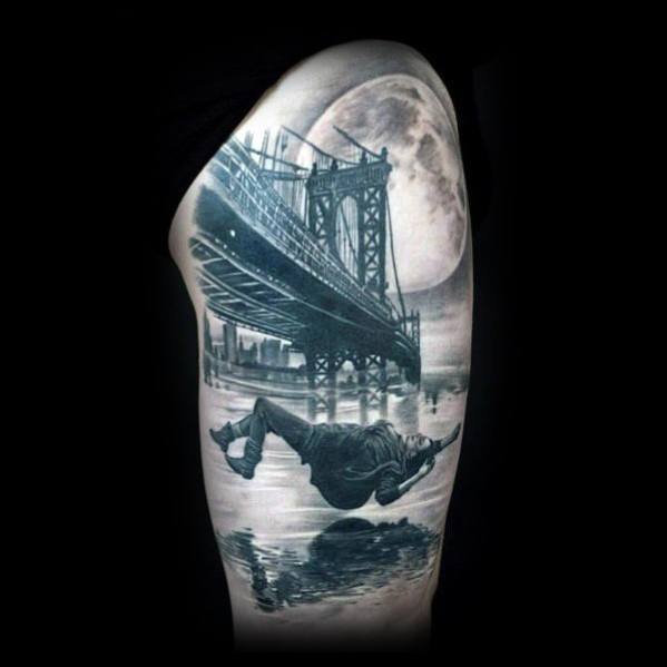 Realistic tattoo of a man falling backward beneath a bridge with a full moon in the background, reflected in the water below.
