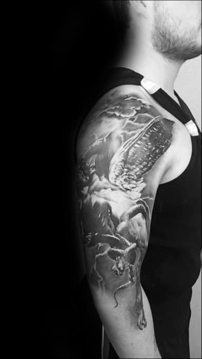 Detailed full-sleeve tattoo of a winged figure falling through stormy clouds, surrounded by lightning and dramatic shading.