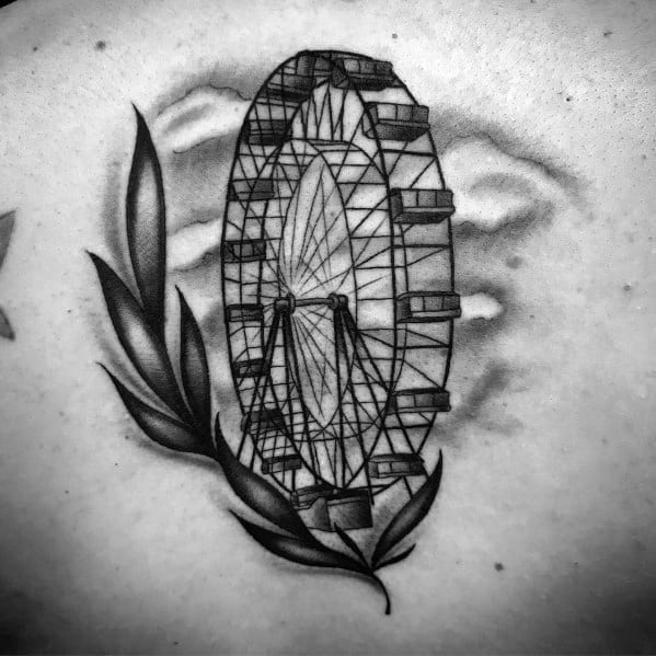 Black and grey Ferris wheel tattoo with fine shading, soft clouds in the background, and decorative leaves for a balanced and elegant design.