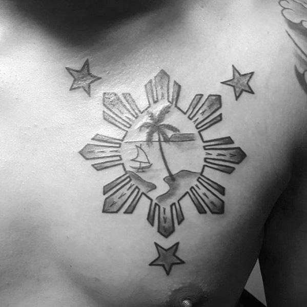 Filipino sun chest tattoo with three stars and an island scene inside the sun, featuring a palm tree, sailboat, and shoreline.