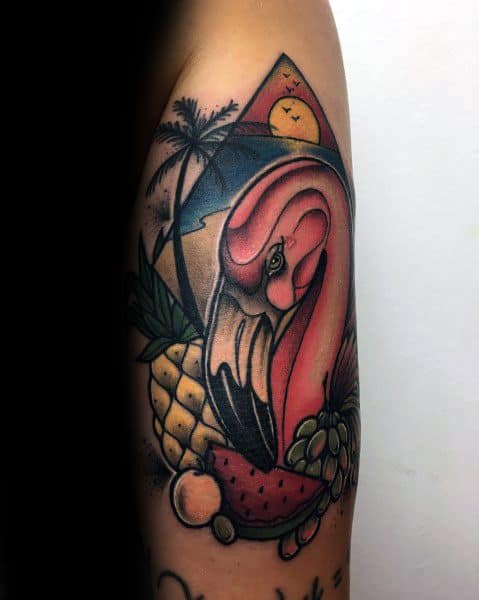Colorful flamingo tattoo with tropical fruits, palm trees, and a sunset, blending summer vibes and bold neo-traditional style.