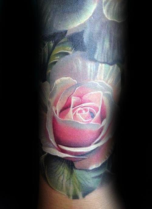 Tattoo of a realistic pink rose with detailed petals and leaves