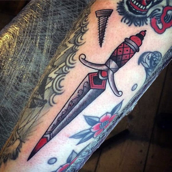 Forearm tattoo of a decorative dagger with a red and black handle