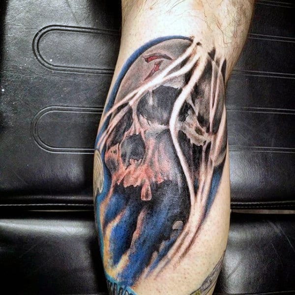 Dark and surreal calf tattoo of a skull with abstract white streaks and deep blue shading, creating a haunting and intense effect