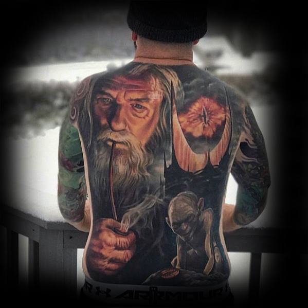 Person reveals a detailed fantasy-themed back tattoo dominated by the Eye of Sauron