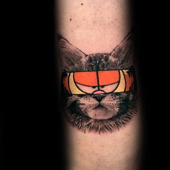 Creative Garfield tattoo blending a realistic cat with Garfield’s iconic eyes—bold contrast of black and orange for a unique design.