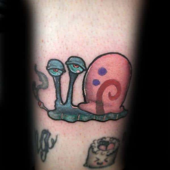 Tattoo of Gary the Snail with a bored expression, holding a cigarette, combining cartoon charm with a rebellious twist.