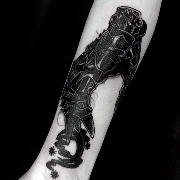 Dark blackwork tattoo of a detailed armored gauntlet gripping a swirling flail, featuring sharp lines and a bold, high-contrast design.