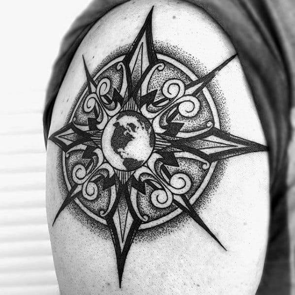 Bold compass tattoo on upper arm with ornamental swirls and Earth at the center, blending global and artistic elements.
