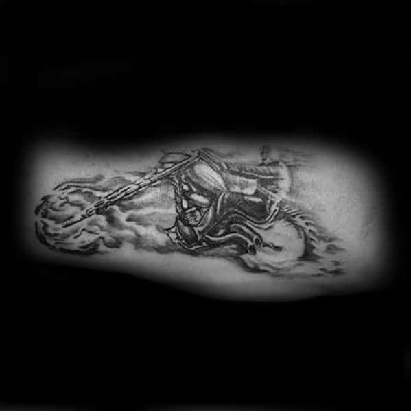 Black and grey Ghost Rider tattoo with a flaming chain, dark motorcycle, and smoke trail, capturing a fierce ride in motion.