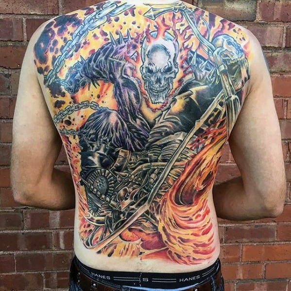 Vibrant full back Ghost Rider tattoo with a flaming skull, roaring motorcycle, swirling fire, and chains set against a fiery sky.