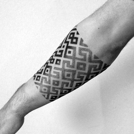 Black and grey gradient tattoo sleeve with repeating geometric square patterns fading out toward the edges on the forearm.