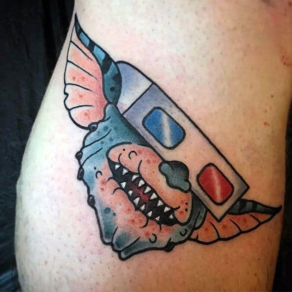 Gremlin tattoo with 3D glasses and a mischievous grin, featuring a bold, cartoon-style design with vibrant shading.
