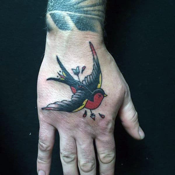 Colorful sparrow tattoo on the back of a hand with outstretched wings