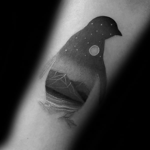 Creative penguin-shaped tattoo with a starry night sky, iceberg, and ocean waves subtly blended into the body silhouette.