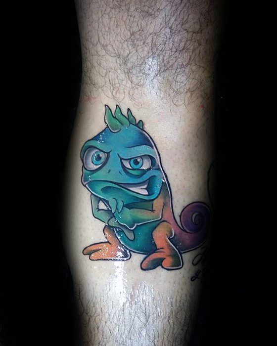 Colorful cartoon-style iguana tattoo with a mischievous grin, bold outlines, and vibrant blue, green, and orange tones.