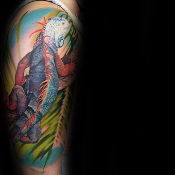 Colorful full-arm iguana tattoo with blue, red, and purple tones, set against a tropical background with leaves and light gradients.