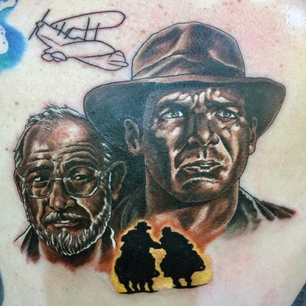 Indiana Jones tattoo featuring Indy and his father, Henry Jones Sr., with a silhouette scene, fedora, and vintage plane sketch.
