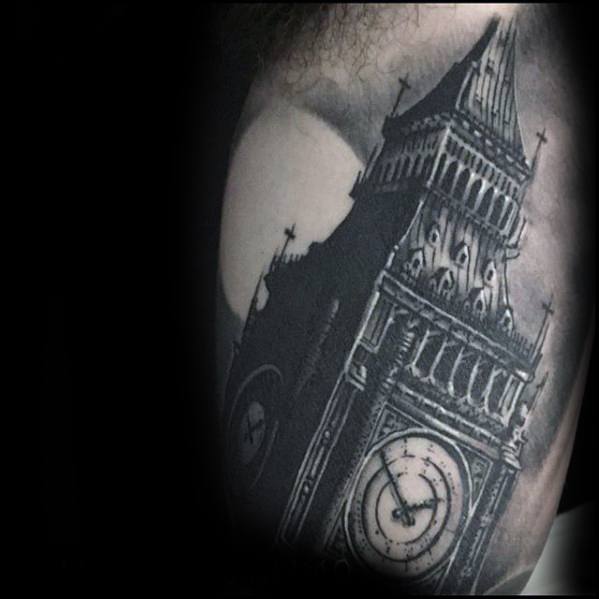 Detailed black and grey tattoo of Big Ben with a moon in the background, showcasing intricate shading and architectural details on the upper arm.