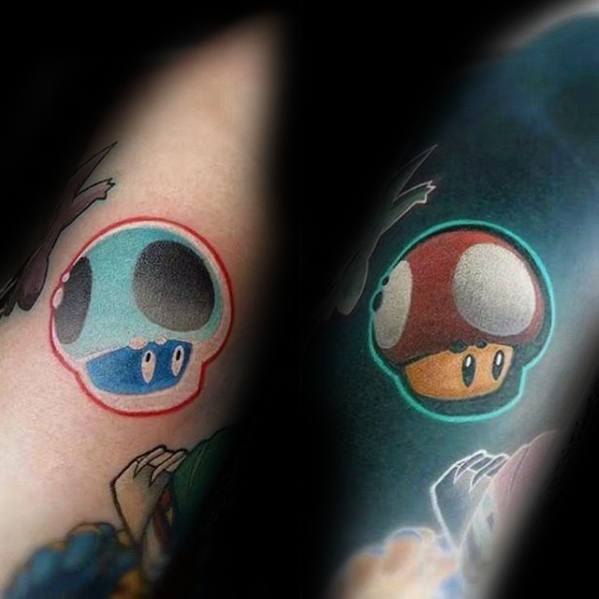Inverted tattoo of a cartoon mushroom character, shifting from light blue with red outline to brown with neon green glow.