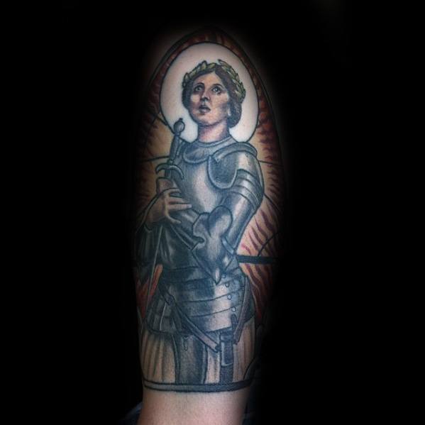 Realistic Joan of Arc tattoo with glowing halo, armor detail, and upward gaze, evoking strength and divine inspiration.