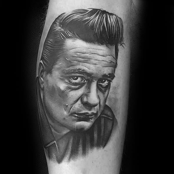 Black and white tattoo of Johnny Cash's serious face on an arm