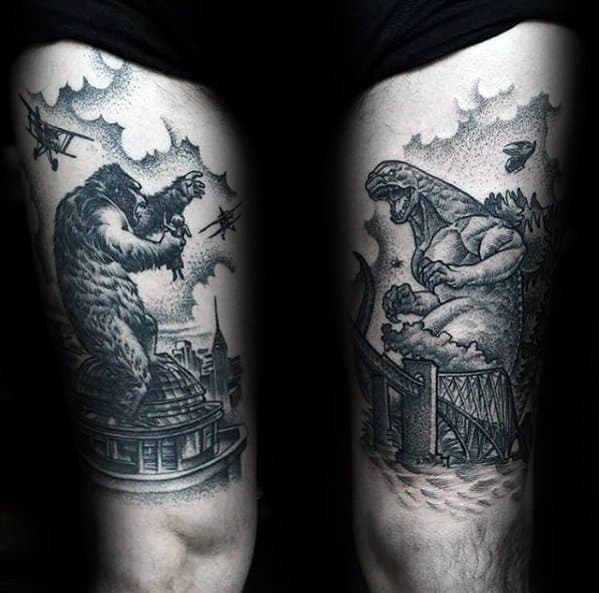 Black and grey thigh tattoos of King Kong battling planes on a dome and Godzilla roaring near a bridge, both in dotwork style.