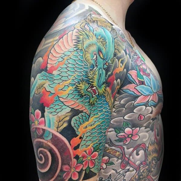Vibrant shoulder and chest Kirin tattoo with teal scales, golden mane, red flames, and cherry blossoms in a dynamic Japanese style.