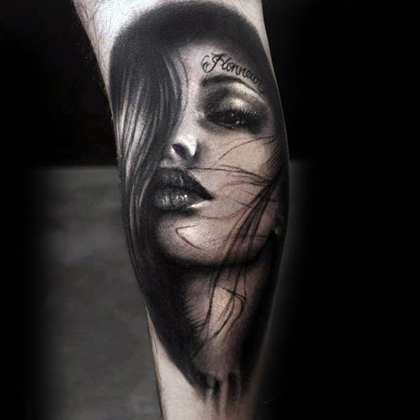 Tattoo of a stylized woman's face with flowing hair and detailed shading on an arm