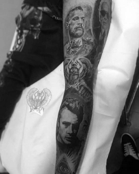 Full forearm tattoo featuring multiple portraits including James Dean at the bottom, a tiger, and an all-seeing eye symbol.