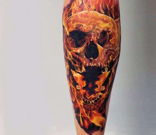 Realistic flaming skull tattoo on a person's leg