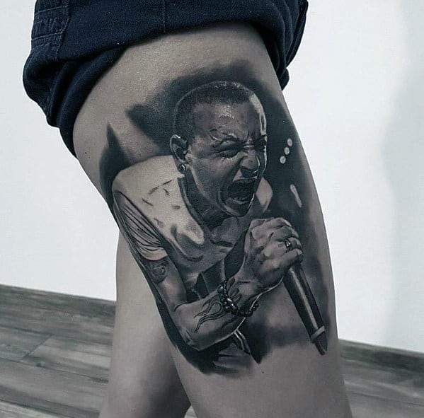 Hyper-realistic black and gray tattoo of Chester Bennington mid-performance, capturing his intense emotion and dynamic stage presence.