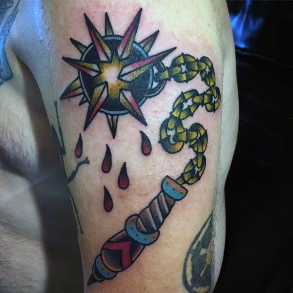 Colorful mace tattoo featuring a spiked ball with red and gold details, a chain, and blood drops, symbolizing power, battle, and strength.