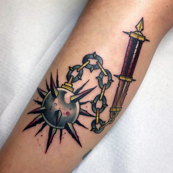 Bold mace and dagger tattoo with a spiked ball on a chain, featuring bloodstains and sharp details, symbolizing battle, power, and resilience.