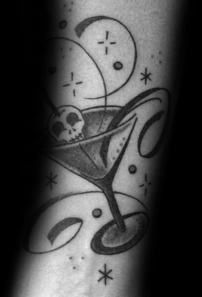 Black and grey martini glass tattoo with a skull garnish and cosmic details. A stylish, mystical design with bold lines and shading effects.