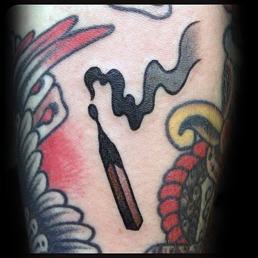 Traditional-style burnt match tattoo with bold black smoke, symbolizing endings, resilience, or moments that leave a mark.