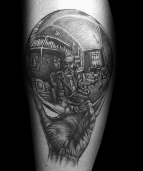 Realistic tattoo of MC Escher’s “Hand with Reflecting Sphere,” showing the artist seated in a room reflected in a glass orb.
