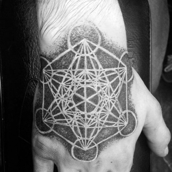 Metatron’s Cube hand tattoo with bold white ink lines over dark dotwork shading, creating a high-contrast sacred geometry design.